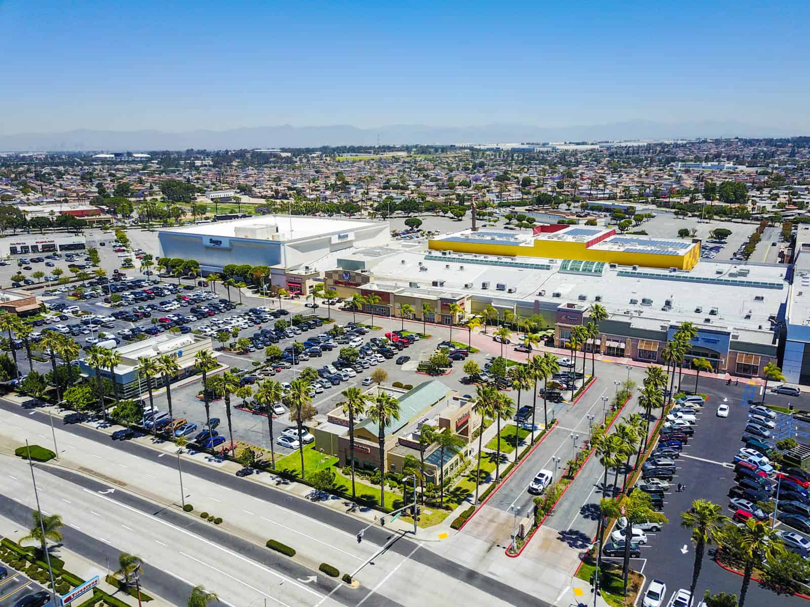 aerial photo of a shopping plaza with palm trees in California