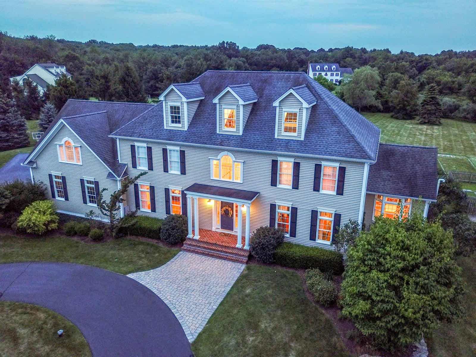 close up drone photo of residential property at dusk with lights on in Guilford, CT