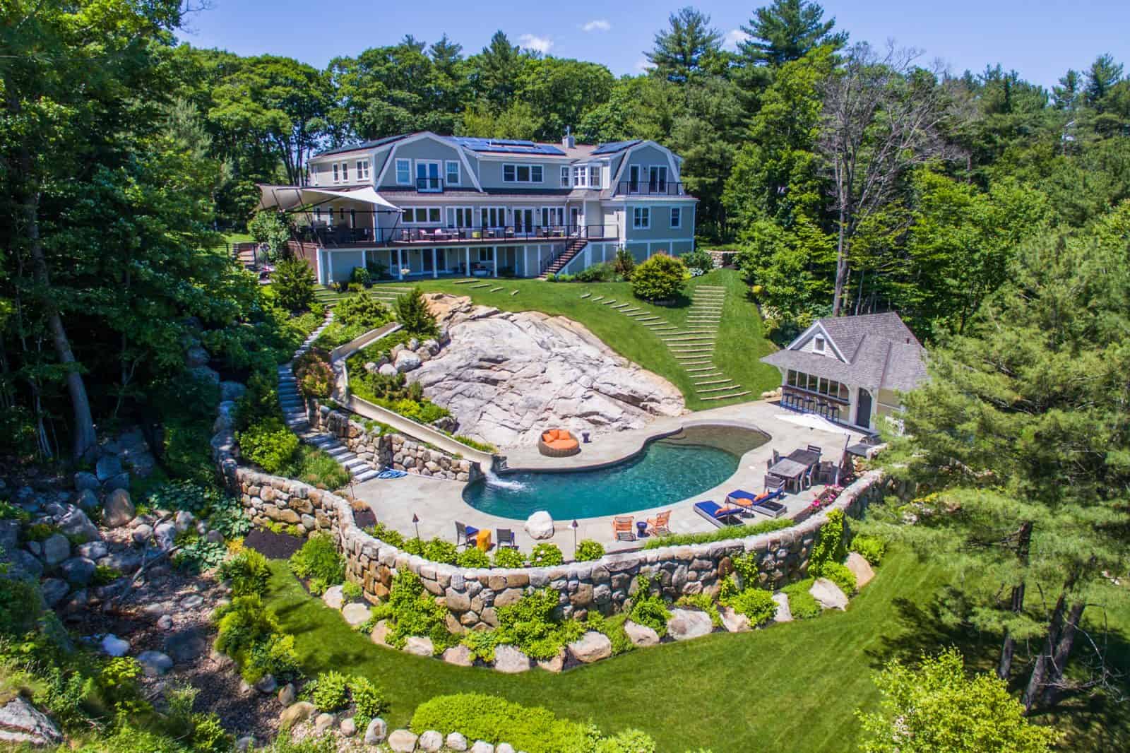 aerial drone photo of house with solar panels, a pool, and an outdoor patio