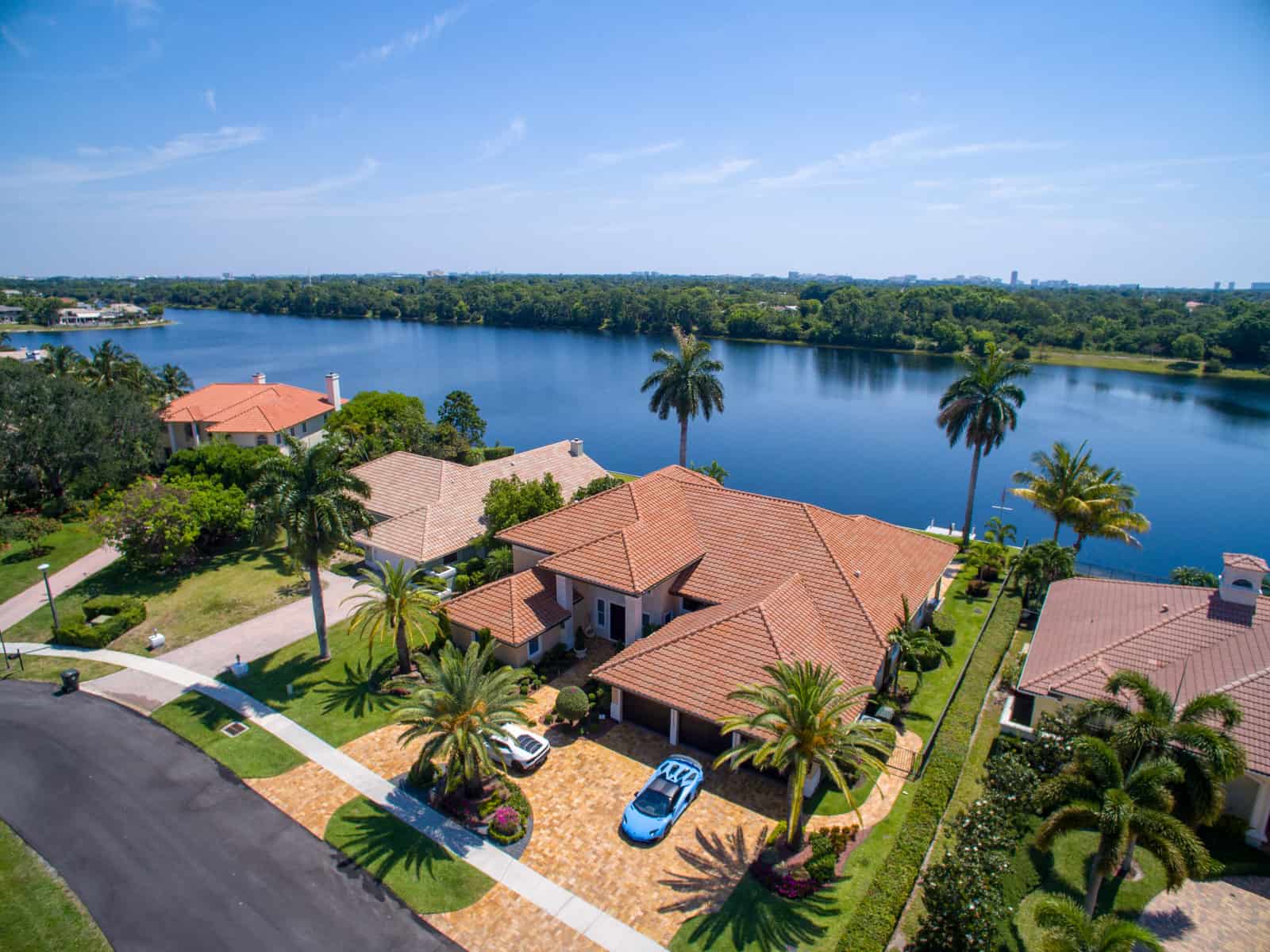 house in Boca Raton, FL, with lake in background and two Ferrari's parked in the driveway