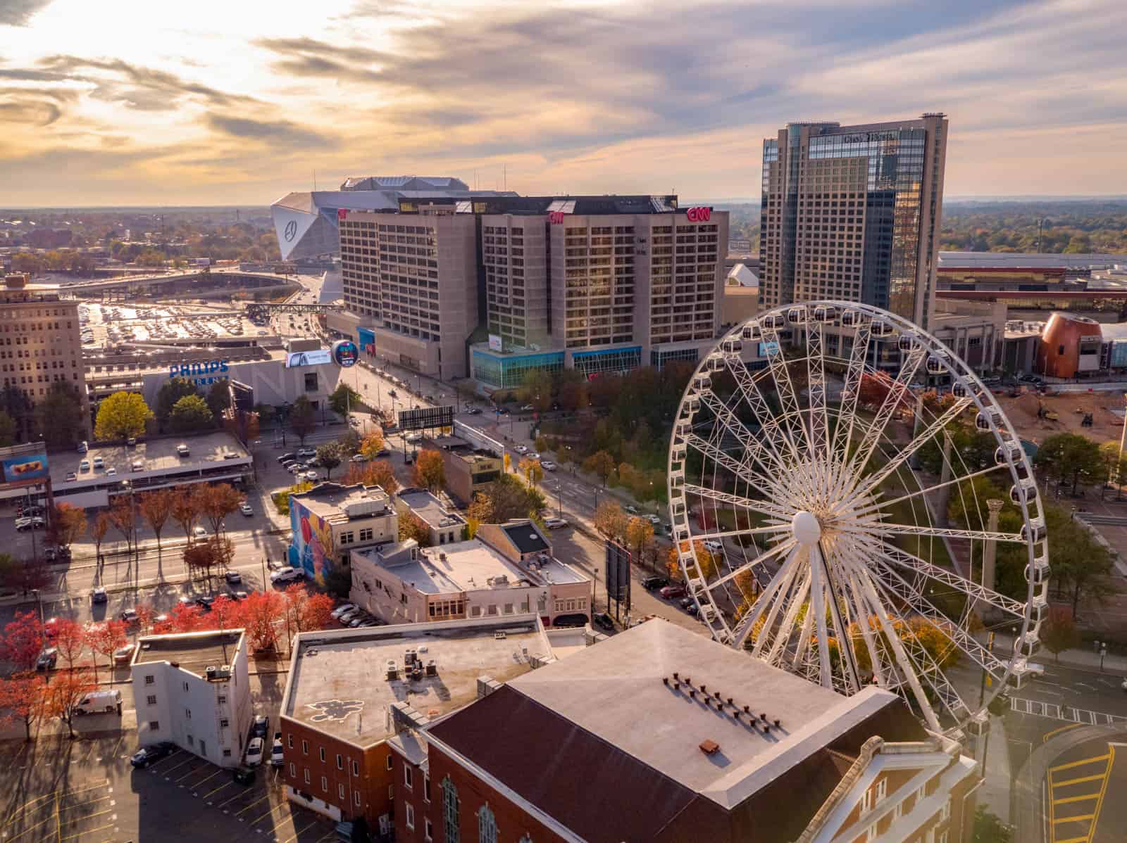 aerial drone photo of ferris wheel, office building, streets, and sunset in Atlanta, GA