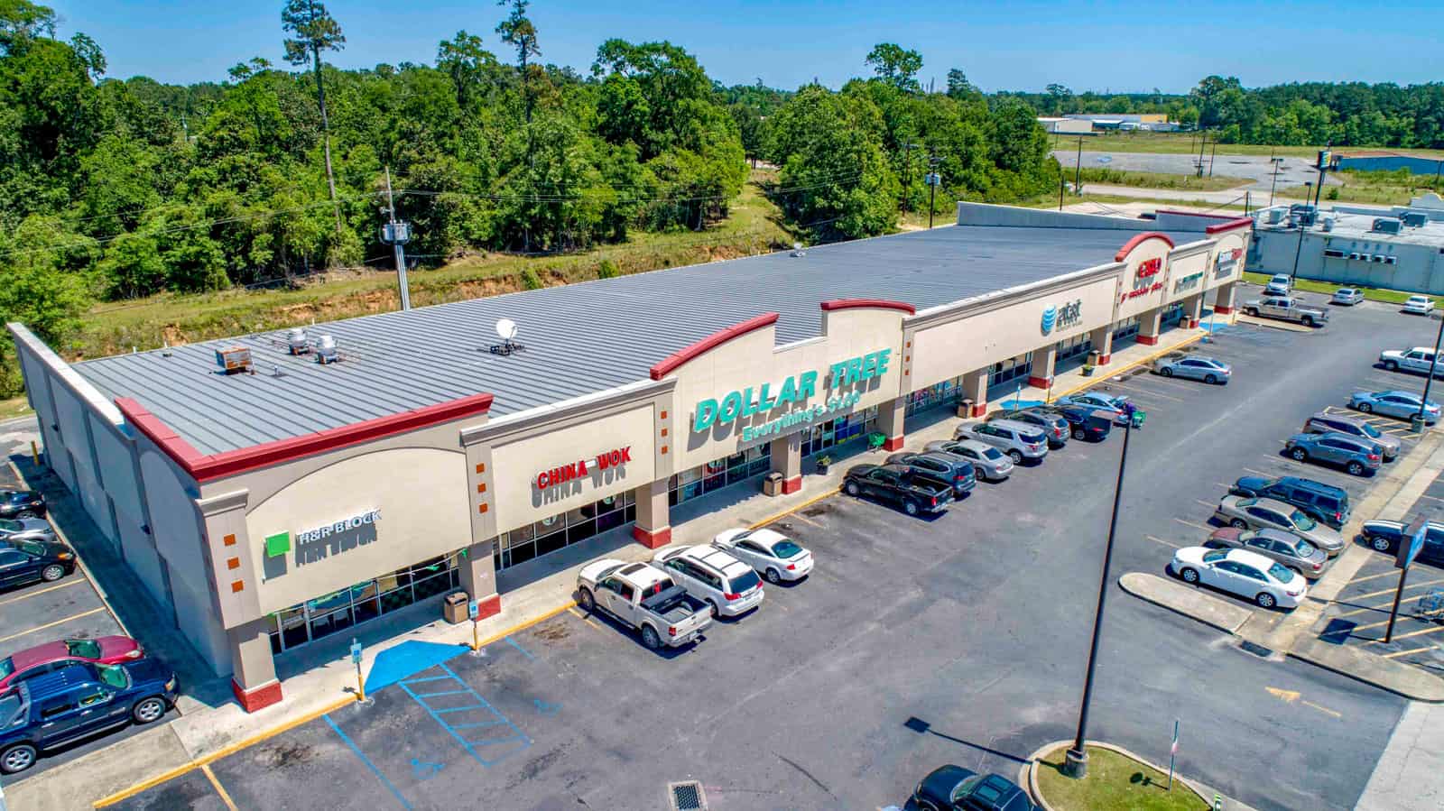 shopping plaza with Dollar Tree store and full parking lot drone photo in Louisiana