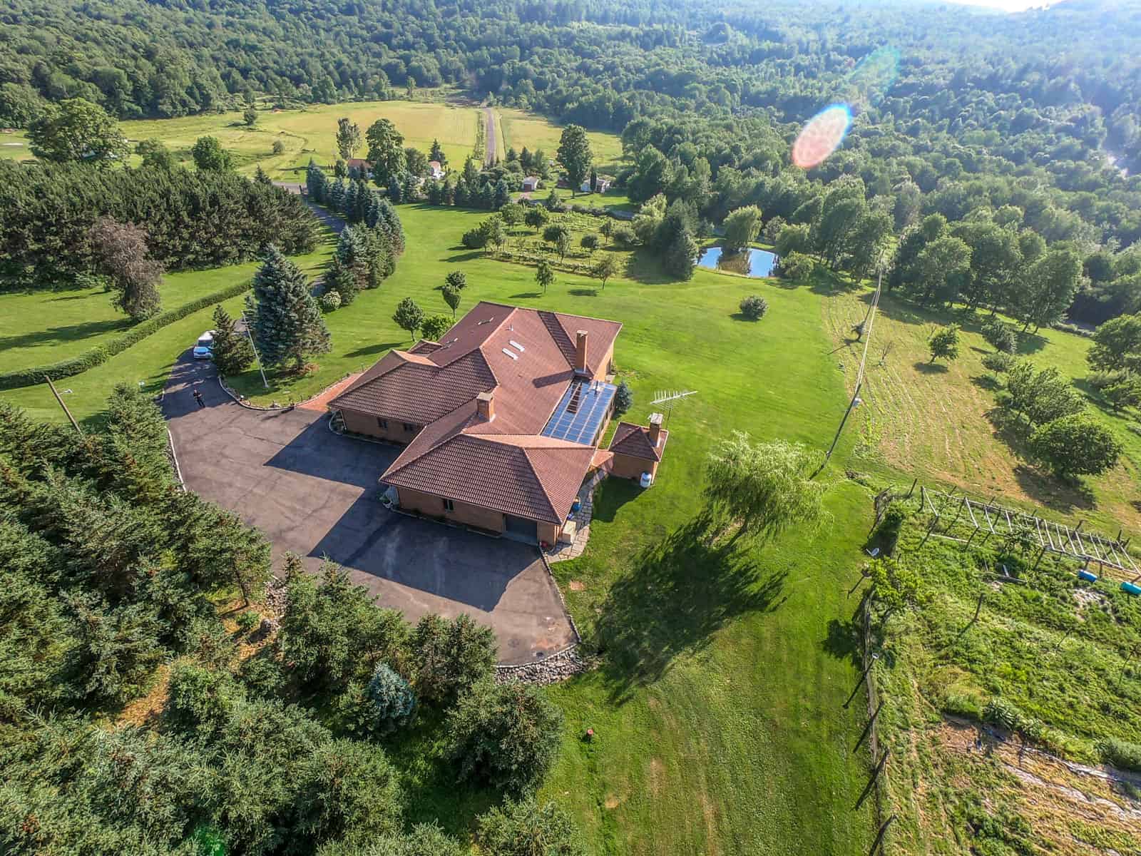 aerial drone photo of a residential real estate property located in upstate New York surrounded by trees and nature