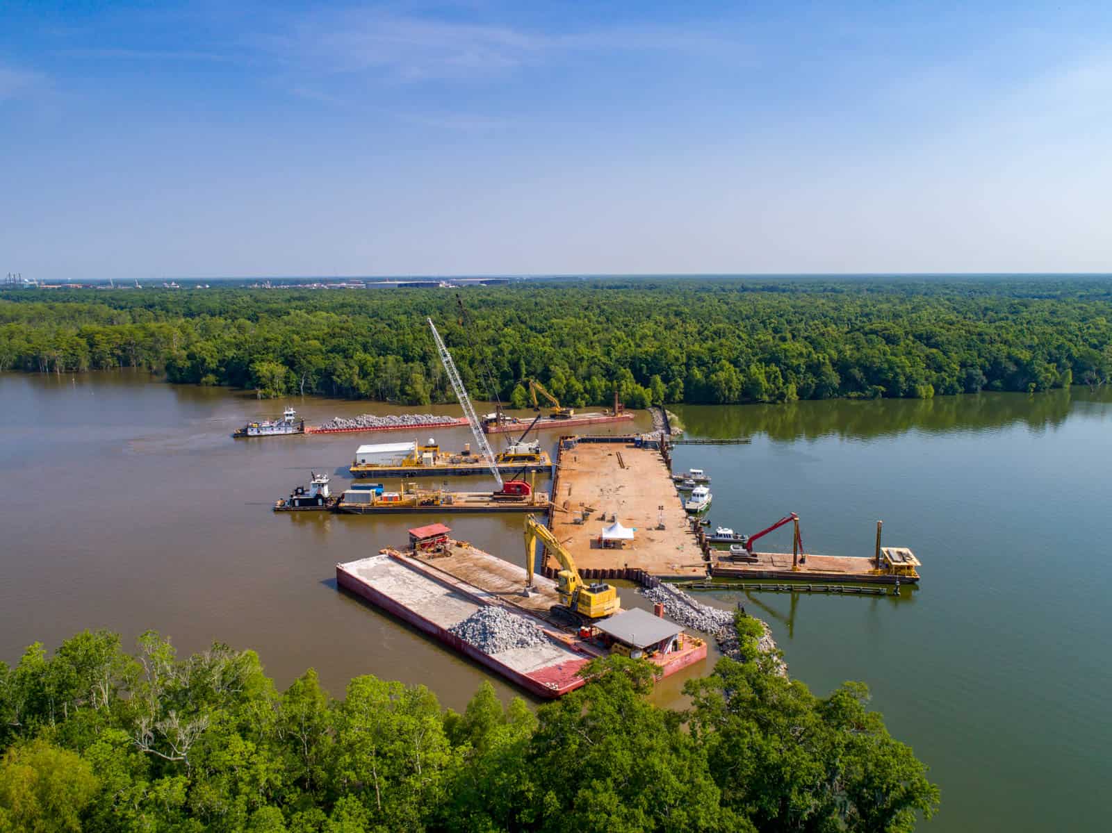 Aerial drone photo of boats on water building dam and cleaning water in Amelia, LA