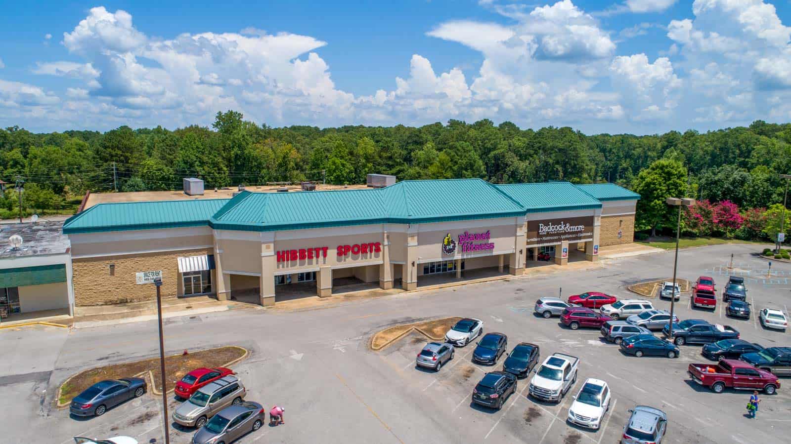 low altitude drone photo of retailer storefronts in commercial strip mall in Jasper, AL